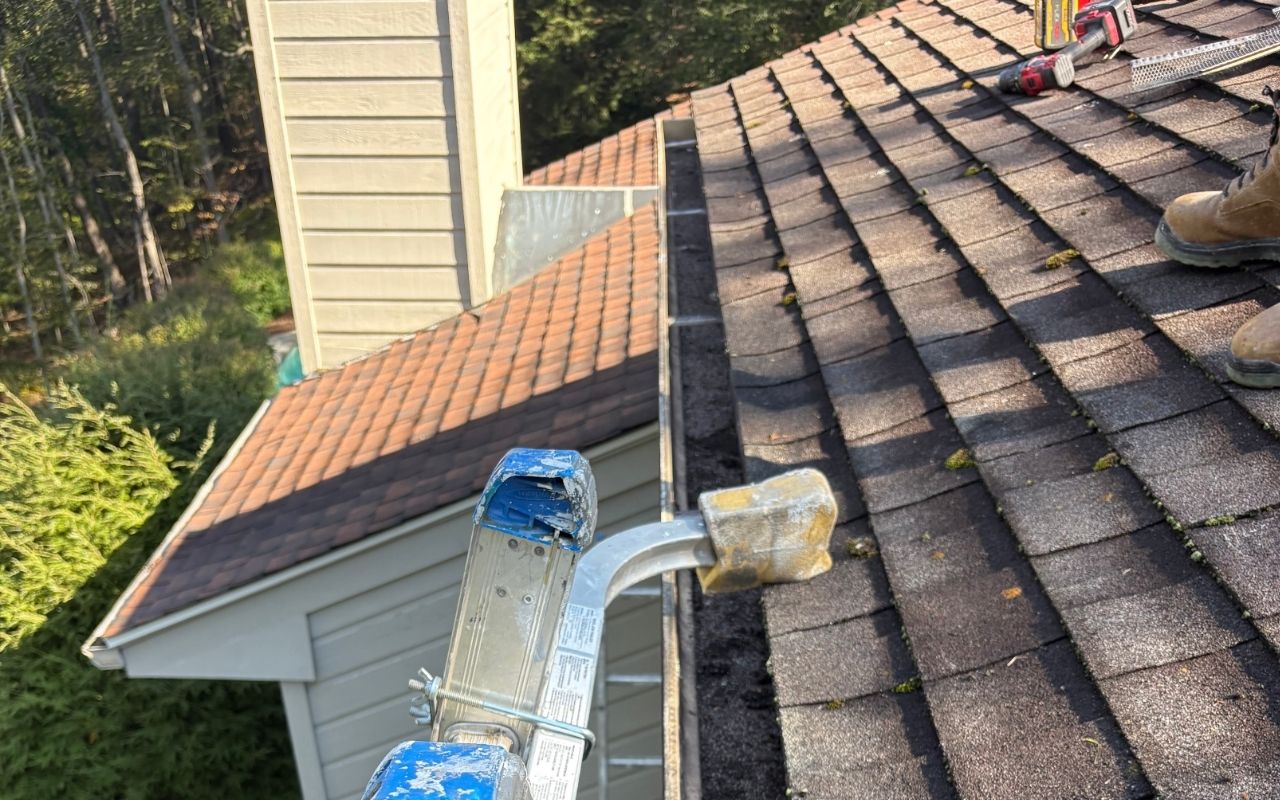 Homeowner cleaning gutters for fall home maintenance Ridgefield