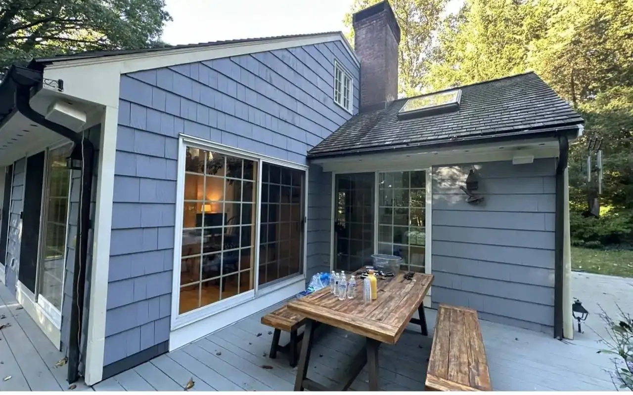 Homeowner doing a post winter gutter inspection on a house in early spring